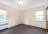 Spare room featuring healthy amount of natural light and radiator