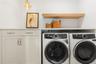 Second floor laundry room with built in storage hampers in cabinet