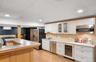 Kitchen with glass insert cabinets, beverage cooler, appliances with stainless steel finishes, a paneled ceiling, and light wood-style floors