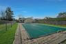 View of pool featuring a yard and fence