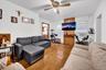 Living area with light wood-type flooring, radiator heating unit, and ceiling fan