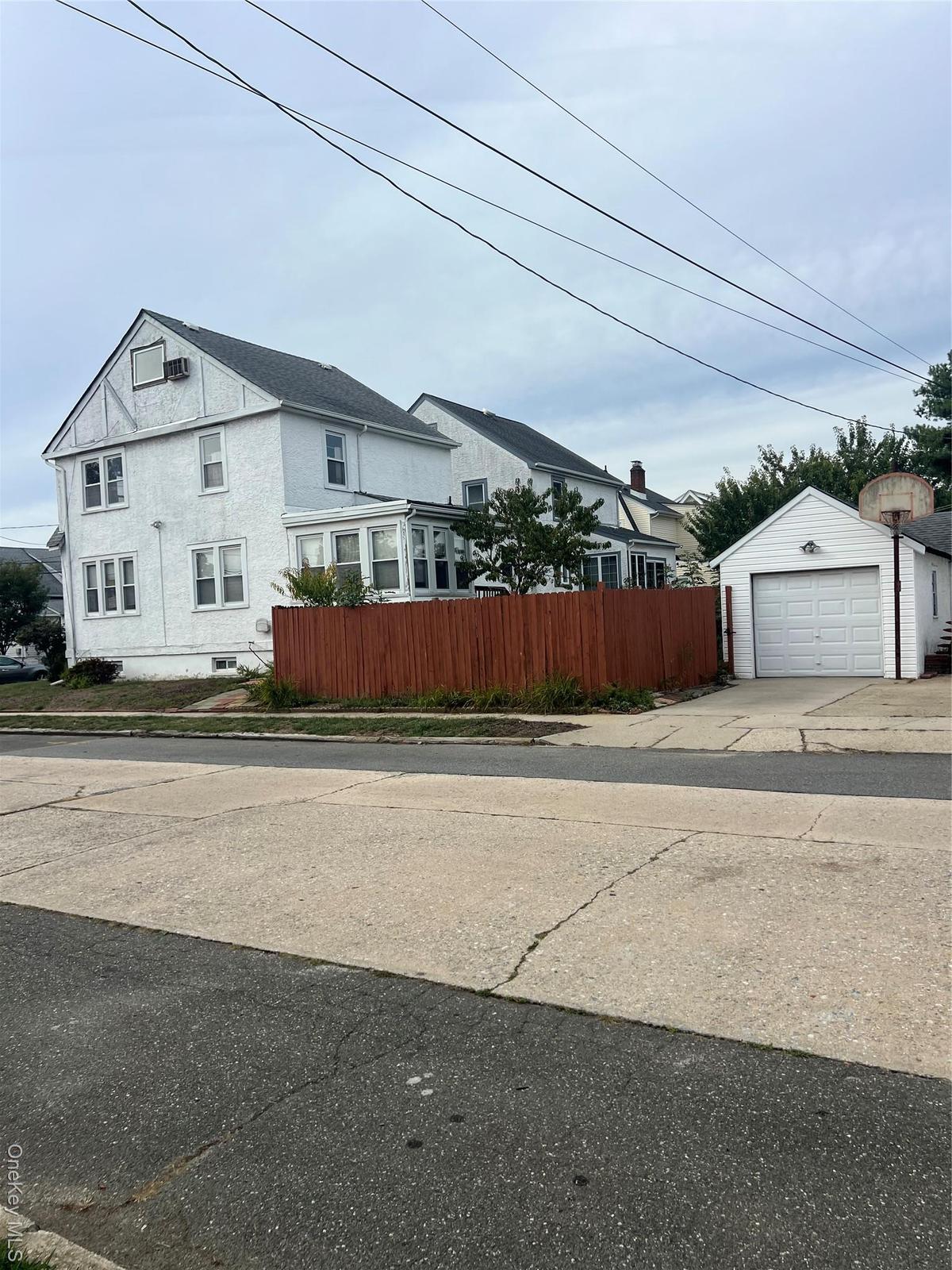 View of home's exterior with a garage, an outbuilding, and driveway