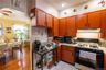 Kitchen featuring range with gas stovetop, light countertops, arched walkways, black microwave, and wallpapered walls