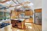 Kitchen with vaulted ceilings, exposed wood beams and skylights.