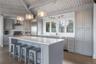 Kitchen with a sink, wall chimney range hood, stainless steel appliances, and gray cabinets