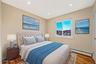Bedroom with baseboard heating, wood finished floors, and recessed lighting