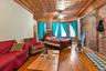 Bedroom with a baseboard heating unit, ornamental molding, hardwood / wood-style floors, and brick wall