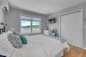 Bedroom with a wall unit AC, light wood-style floors, and a closet