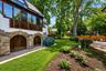 Stone-clad arched garage doors with wood paneling