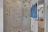 Full bathroom with a marble finish shower and wood finished floors