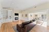 Living room with a wainscoted walls, light wood flooring, and a glass covered fireplace.