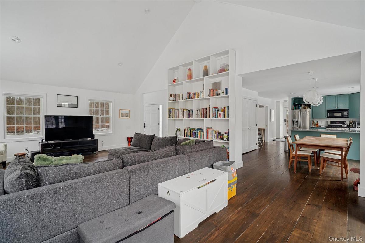 Living room featuring high vaulted ceiling and dark wood finished floors