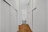 Hallway featuring wood-finish parquet flooring and white sliding closet doors