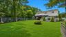 Expansive green lawn with mature perimeter trees