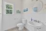 White beadboard paneling, pedestal sink, chrome faucet, and tiled flooring
