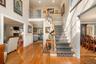 Staircase featuring a towering ceiling, a fireplace, hardwood / wood-style floors, a decorative wall, and recessed lighting
