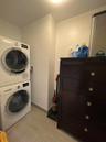 Washroom featuring stacked washer and clothes dryer, baseboards, and laundry area