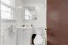 Half bath with vanity, tile walls, and radiator