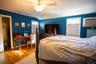 Bedroom featuring light wood-style flooring, a closet, lofted ceiling, a ceiling fan, and an AC wall unit