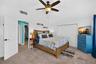Primary bedroom featuring vaulted ceilings and coastal décor.