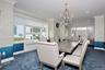 Dining room featuring radiator heating unit, dark colored carpet, ornamental molding, and a chandelier
