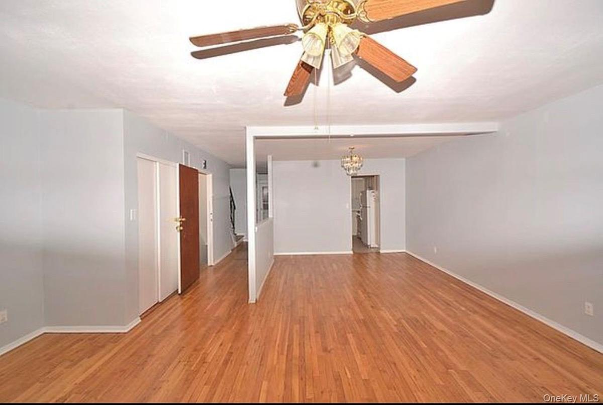 3rd Floor living room featuring light wood-style floors, a living room chandelier, and a ceiling fan
