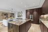 Kitchen with dark brown cabinetry, modern cabinets, a kitchen island, and recessed lighting