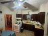 Kitchen featuring white appliances, light countertops, dark brown cabinets, and extractor fan
