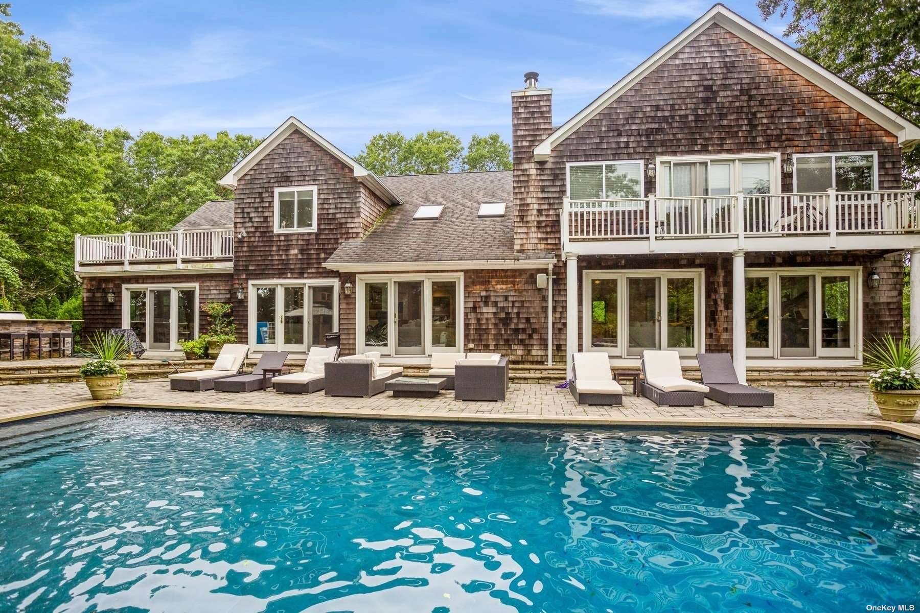 Set on two bucolic acres in Quogue adjoining a 6.