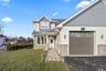 Craftsman house with stone siding, a front yard, and roof with shingles