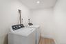 Laundry area featuring light wood-style flooring, washing machine and dryer, and recessed lighting