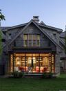 Back of house featuring stone siding, a balcony, and a yard