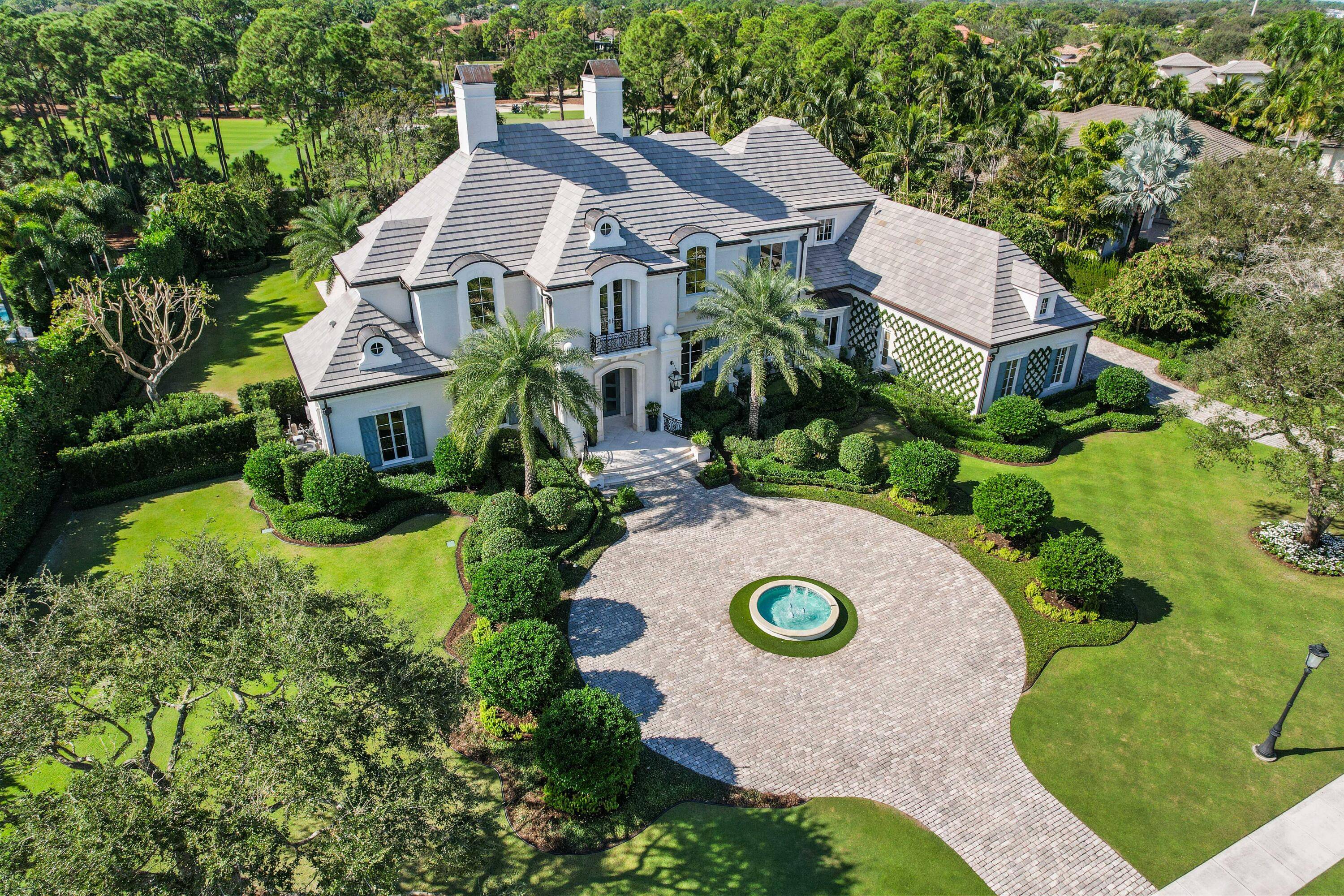 This stunning home, nestled on a 1 acre plot within the prestigious Old Palm Golf Club, emanates European elegance.