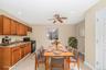 Kitchen featuring brown cabinetry, black range with gas cooktop, light tile patterned floors, a ceiling fan, and recessed lighting