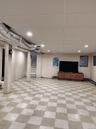 Finished below grade area with light floors, stairs, a drop ceiling, and recessed lighting