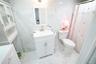 Bathroom featuring vanity, a shower with shower curtain, stone wall, light marble finish floors, and tile walls