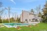 Pool with a wooden deck, a lawn, and fence