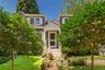 Shingle-style cottage featuring a gabled entry, white trim, and multi-pane windows with decorative shutters