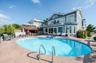 Rear view of house featuring a patio, an in-ground hot tub, and a balcony