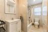Bathroom featuring tile walls, shower / bathtub combination with curtain, and vanity