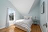 Bedroom featuring vaulted ceiling, baseboards, and hardwood / wood-style floors