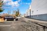 Paved parking area with marked spaces, featuring a multi-story building facade with white and gray paneling