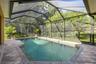 Private screened saltwater pool overlooking lush backdrop