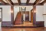 Stairs with ornate columns, hardwood / wood-style flooring, beam ceiling, radiator heating unit, and ornamental molding