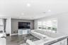 Spacious living area featuring wood-finish flooring, recessed lighting, and a prominent accent wall
