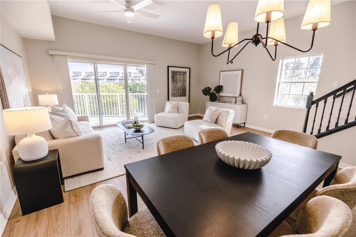 Open concept living and dining room with natural light and balcony overlooking mangroves.