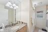 Full bath featuring vanity, light tile patterned floors, a chandelier, and a shower with curtain