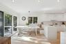 Kitchen with pendant lighting, white cabinets, sink, kitchen peninsula, and a breakfast bar area