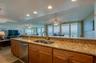 Enjoy breathtaking ocean views directly from the kitchen sink, with an open sightline through the dining and living areas to the balcony beyond.