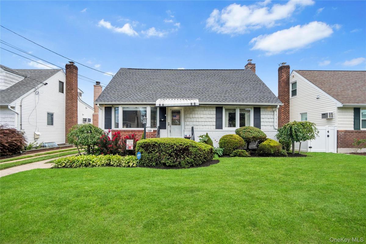 Gable roofline, exterior siding with brick accents, prominent front windows, front entry awning, and established front landscaping